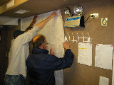 Jim Wilson hangs his maps with the help of Jonathan Emmett an Lucas Swartwood. (R.Rilling, 2002-May-13)
